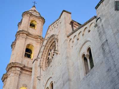 L�imponente facciata composta da bianchi conci di pietra regolari si divide in tre fasce di cui la centrale � la pi� grande. Questa, scandita verticalmente da due paraste, presenta un timpano triangolare sulla sommit� decorato con archetti rampanti che terminano con una cornice dentellata